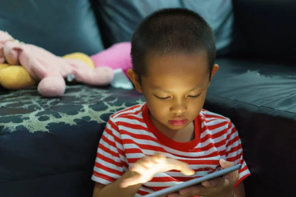 Bijgesneden weergave van kleine jongen met behulp van een digitaal tablet thuis — Stockfoto