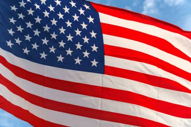 Yıldız ve çizgili mavi gökyüzüne Amerikan bayrağı sallayarak