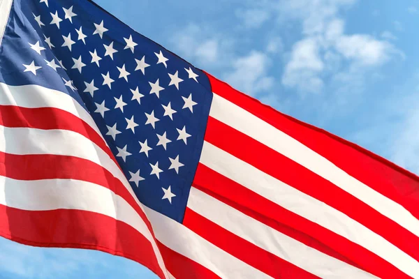 Waving star and stripes American flag on the blue sky — Stock Photo, Image