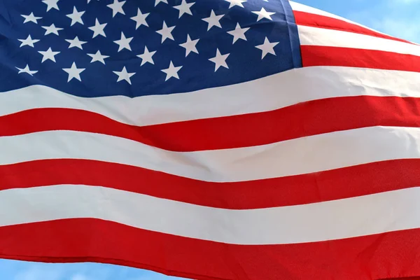 Waving star and stripes American flag on the blue sky — Stock Photo, Image