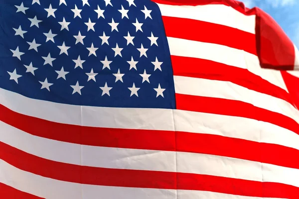 Waving star and stripes American flag on the blue sky — Stock Photo, Image