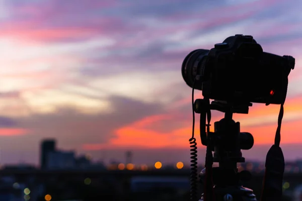 Silhouette de l'appareil photo prend une photo du crépuscule à th — Photo