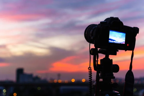 Silhouette de l'appareil photo prend une photo du crépuscule à th — Photo