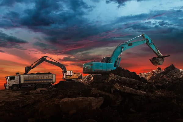 Chargeuse-pelleteuse sur chantier au coucher du soleil fond du ciel — Photo