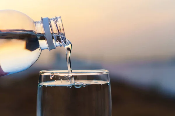 Nalijte vodu do sklenice v přírodě doma — Stock fotografie