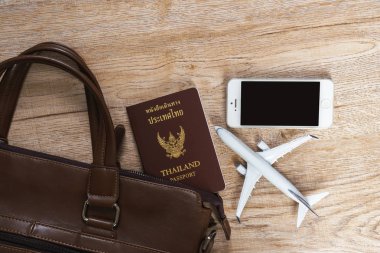 Tayland pasaportu, deri çanta, telefon ve küçük uçak woode üzerinde model