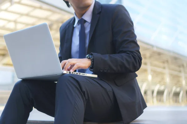 Homme d'affaires assis sur les traces avec ordinateur portable — Photo