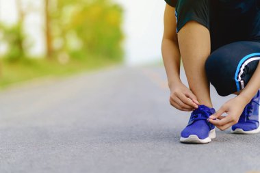 Kız koşucu koşu ayakkabıları koşu için Heal hazırlanıyor çalışıyor