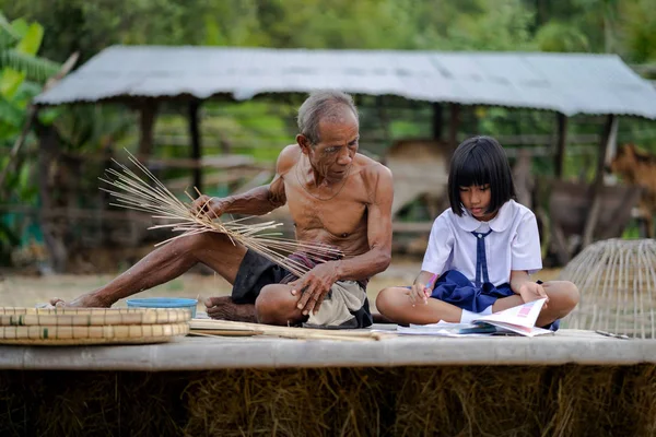 Elderly man with student girl and bamboo craft, lifestyle of the — Stock Photo, Image