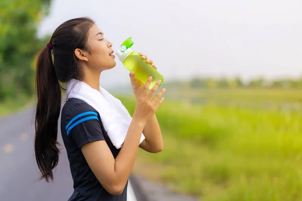 Retrato de hermosa chica en ropa deportiva de agua potable en el o — Foto de Stock