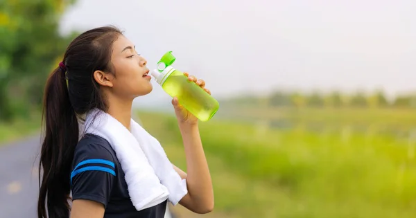 Portrait of beautiful girl in sportswear drinking water in the o — Stock Photo, Image