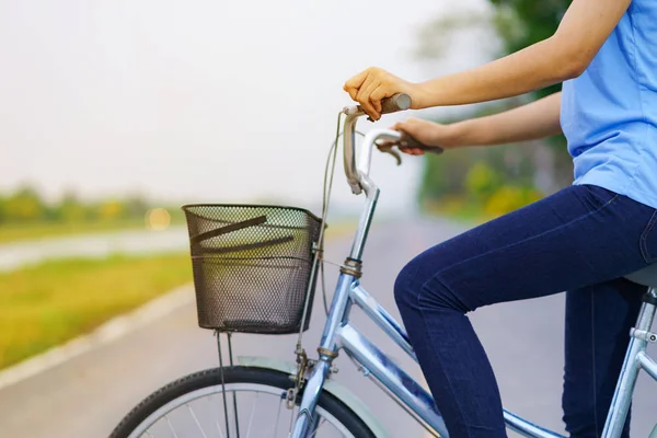 Chica con bicicleta, Mujer montando una bicicleta en la carretera en un parque —  Fotos de Stock