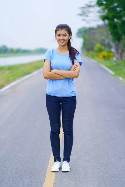 Retrato de menina bonita em camiseta azul e jeans de pé em — Fotografia de Stock