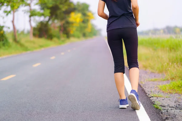 Pies de mujer corriendo por la carretera, Entrenamiento saludable de la mujer fitness — Foto de Stock