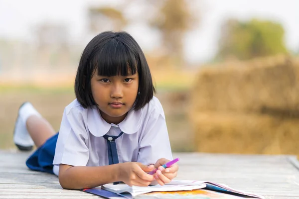 Estudiante asiática en uniforme estudiando en el campo de Tailandia —  Fotos de Stock