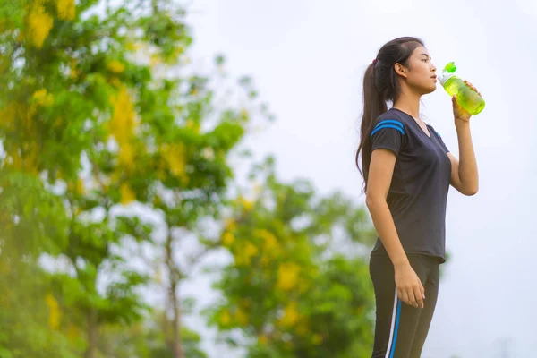 Retrato de hermosa chica en ropa deportiva de agua potable en el o — Foto de Stock