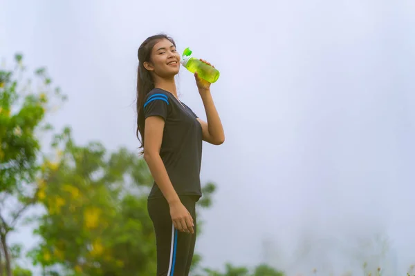 Portret van mooi meisje in sportkleding drinkwater in de o — Stockfoto