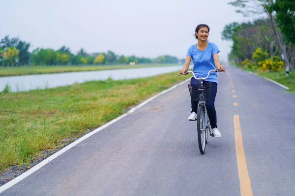 Ragazza in bicicletta, Donna in bicicletta su strada in un parco — Foto Stock