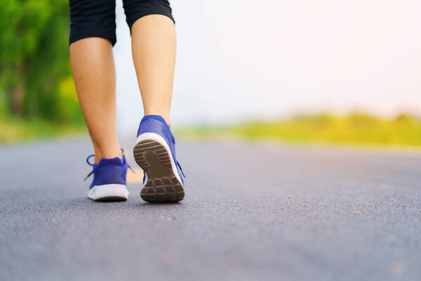 Woman feet running on road, Healthy fitness woman training