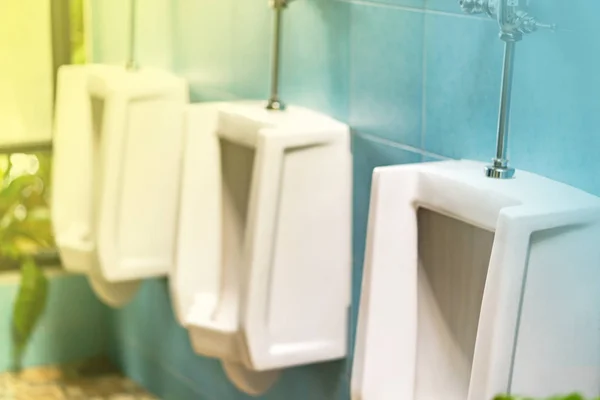 Rij van witte urinoirs in het mannelijke toilet — Stockfoto