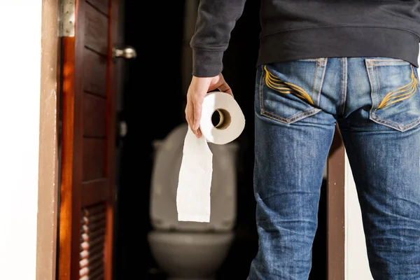 Man hålla vävnad rulle i toalett — Stockfoto