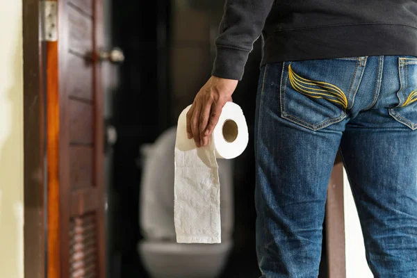 Homem segurando rolo de tecido no banheiro — Fotografia de Stock