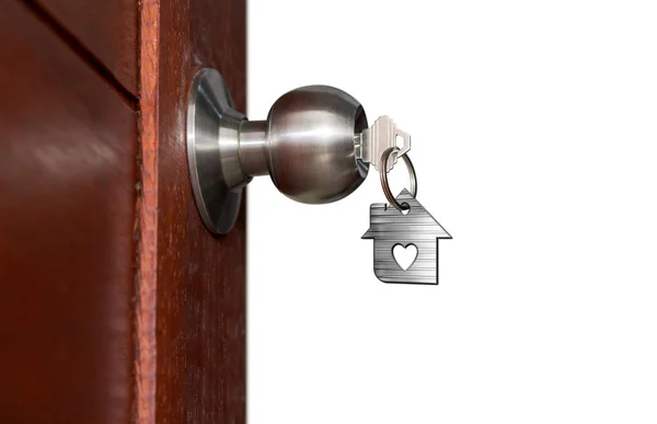 Porta aberta com chaves, chave da casa no buraco da fechadura com casa pequena — Fotografia de Stock