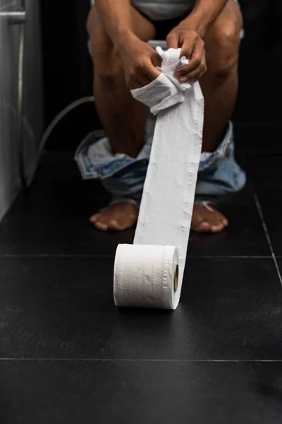 Man holding tissue roll in toilet of his house — Stock Image Man holding tissue roll in toilet of his house Royalty Free Stock Images
