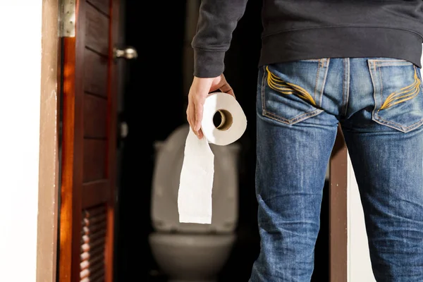 Man holding tissue roll in toilet — Stock Image Man holding tissue roll in toilet Royalty Free Stock Photos
