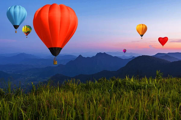 Воздушный шар в сумерках над высокими горами на закате — стоковое фото
