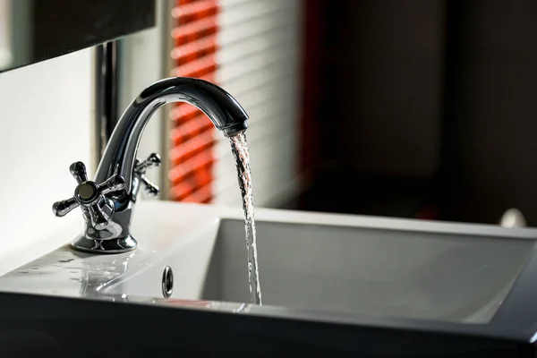 Grifo y flujo de agua en el baño —  Fotos de Stock