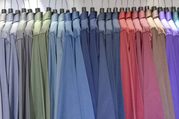 Primer plano de camisas multicolores en perchas, ropa colorida cl — Foto de Stock