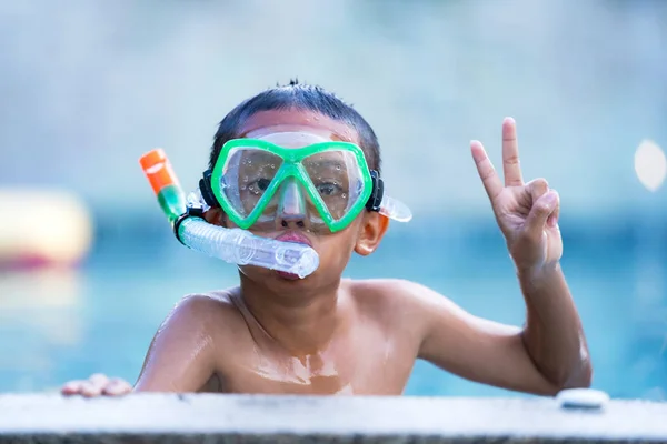 Vista de niño con gafas de baño flotando en la piscina —  Fotos de Stock