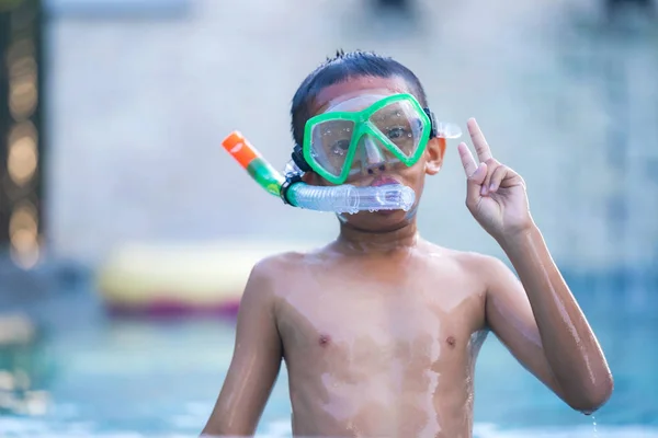 Vista de niño con gafas de baño flotando en la piscina —  Fotos de Stock