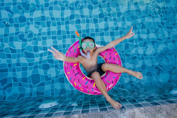 Vista de niño con anillo de natación flotando en la piscina —  Fotos de Stock
