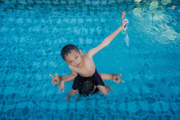 Vista del hombre y el niño con anillo de natación flotando en la piscina —  Fotos de Stock