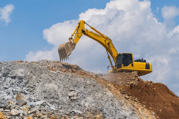 Excavator working outdoors under blue sky — 스톡 사진