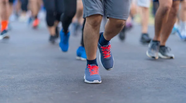 Maratón corriendo personas pies en la carretera en la luz al amanecer — Foto de Stock