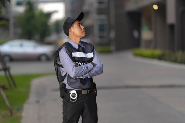 Uomo della sicurezza in piedi all'aperto vicino a grande edificio — Foto Stock
