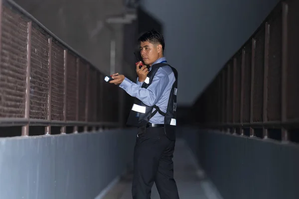 Security man standing outdoors using portable radio — Stock Photo, Image