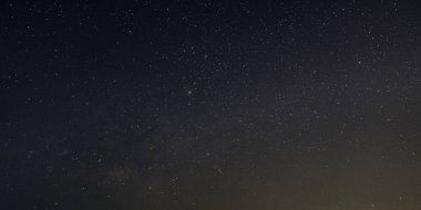 Samanyolu Galaksisi 'nin gece gökyüzü arka planında yıldızlarla panorama görüntüsü