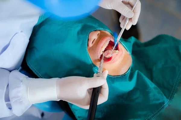 치과에서 일하고 의사가 봉합을 가지고 장갑을 의사의 아이에게 치아를 치료하고 — 스톡 사진