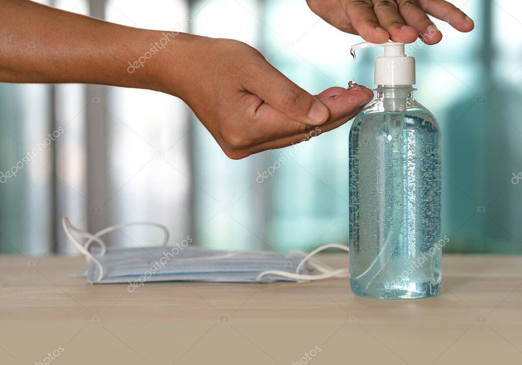 Hand with Alcohol Gel Hand Sanitizer and Medical Mask on table, Clean hands hygiene prevention of coronavirus, During the epidemic covid-19