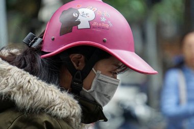Hanoi, Şubat 2020: Asyalı sağlık koruması olarak yüz maskesi takıyor