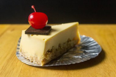 Parçası cheesecake kiraz ahşap masa ve karanlık adam ile