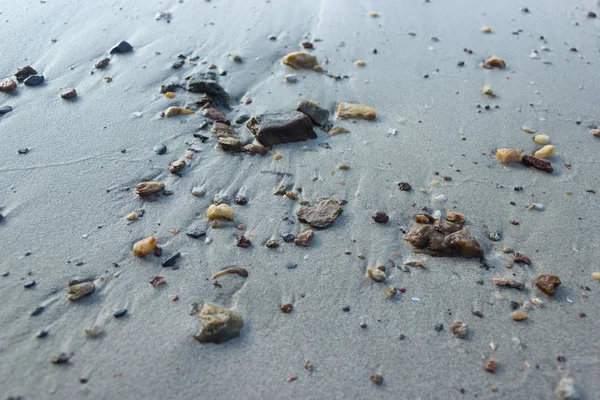 Guijarros en una playa de arena por la mañana — Foto de Stock