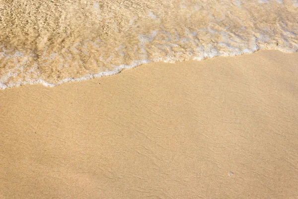 Morbide onde con schiuma di oceano sullo sfondo della spiaggia sabbiosa — Foto Stock