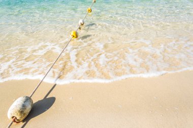 Mavi plaj ve yumuşak dalgalar köpük arka plan ile şamandıralar