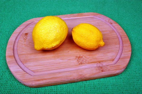 Two fresh lemons on a wooden board — Stock Photo, Image