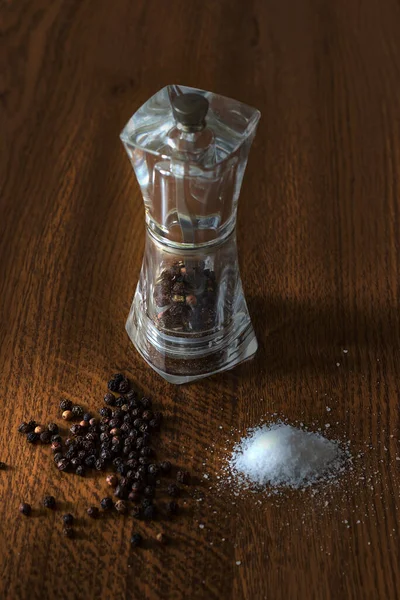 Pepper shaker with balls of black pepper and salt